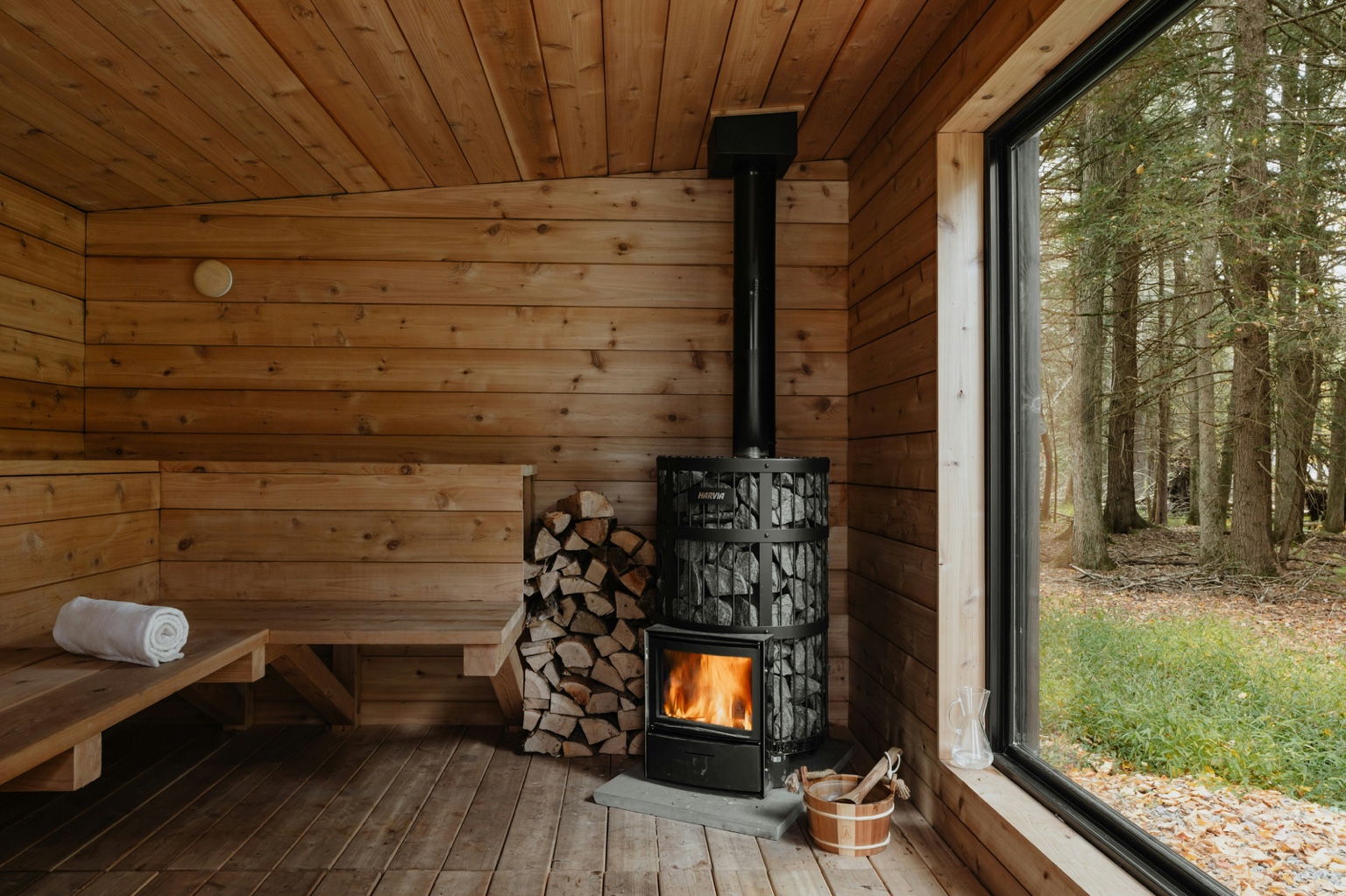 Traditional sauna interior with wood stove and outdoor view